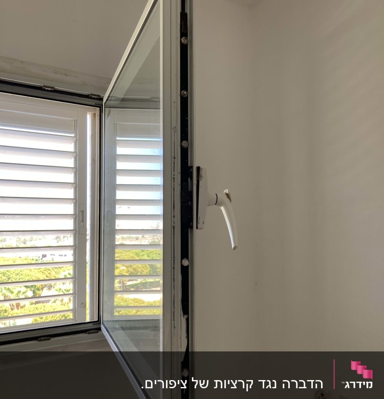 חלון פתוח עם ידית לבנה